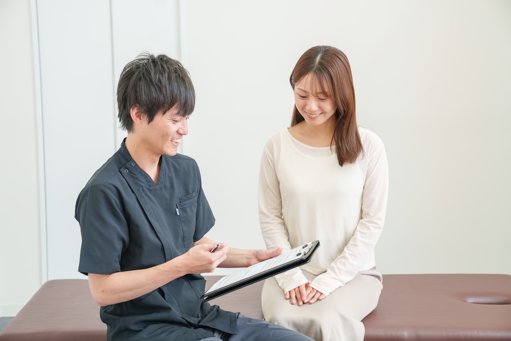 問診を行う施術者と患者
