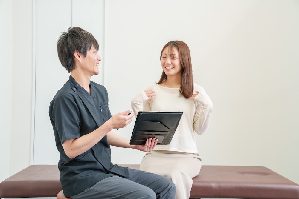 タブレット画面を見せて説明する施術者