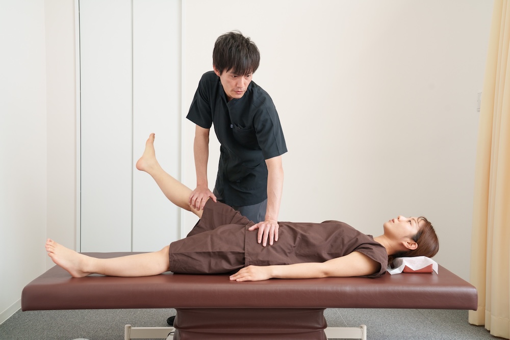 患者の腰や脚を整える施術者