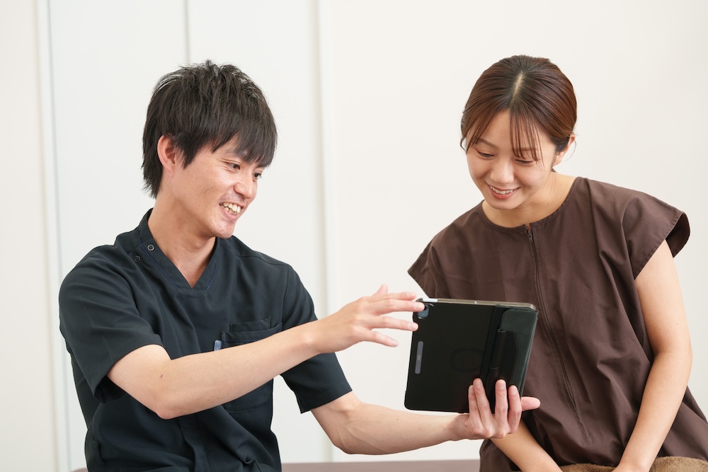 立位で患者の姿勢を確認する院長